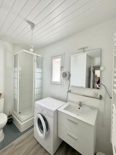 une salle de bain blanche avec une machine à laver et un lavabo dans l'établissement appartement 4 pers 50 m plage 4B237, au Barcarès
