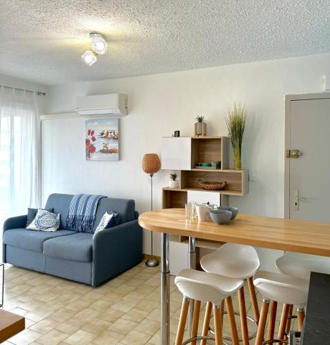un salon avec un canapé bleu et une table dans l'établissement appartement 4 pers 50 m plage 4B237, au Barcarès