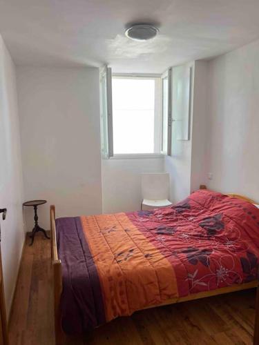 une chambre avec un lit avec une couverture rouge et une fenêtre dans l'établissement Appartement dans maison de village, à Piana