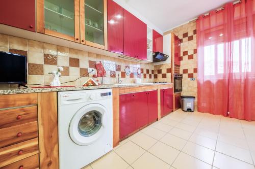 a washing machine in a kitchen with red cabinets at Casa Aurora in Pace Inferiore