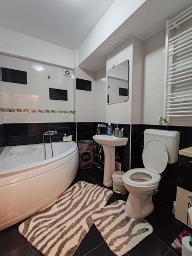 a bathroom with a tub and a toilet and a sink at Alinaalis in Zărneşti