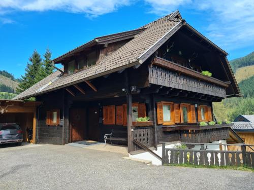 a house in the mountains with a car parked in front at Chalet Mallnock by Globalimmoservice in Bad Kleinkirchheim