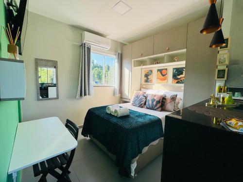 a small bedroom with a bed and a table at Stúdio equipado em Xerém - St 7 in Xerém
