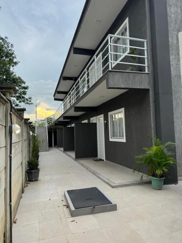 a building with a balcony and a ramp on a patio at Stúdio equipado em Xerém - St 7 in Xerém