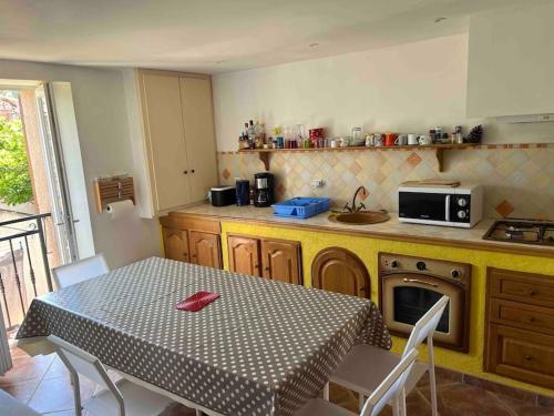 une cuisine avec une table et une cuisine avec une table et des chaises dans l'établissement Appartement dans maison de village, à Piana