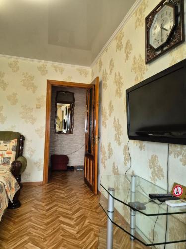 a living room with a tv and a glass table at Центр 6-я слободская Центральный проспект in Mykolaiv