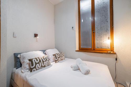 une chambre avec un lit avec deux oreillers et un miroir dans l'établissement 2 Bdr Heart Old Town Nice, à Nice