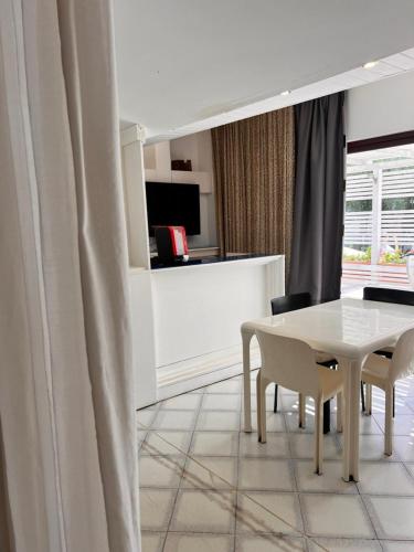 a dining room with a white table and chairs at Villa Aurea in Ispica