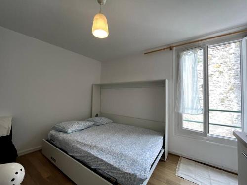 une chambre avec un lit et une fenêtre dans l'établissement Le Studio des Sablons-2 pers-150m place du marche, à Fontainebleau