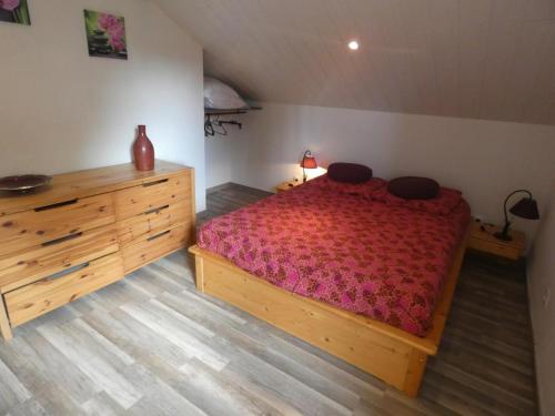 - une chambre avec un lit en bois et une commode en bois dans l'établissement Le gite d'enya, à Saint-Julien-en-Born