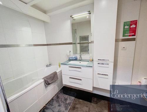 une salle de bain avec un lavabo, une baignoire et un miroir dans l'établissement Chez Lou-Poitiers Hyper Centre-Proche Parking-LaConciergerie, à Poitiers