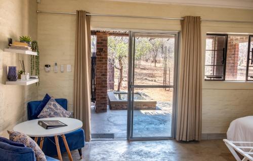 a room with a glass door leading to a patio at Kruger's Retreat House & Kruger's Rest Studio in Marloth Park