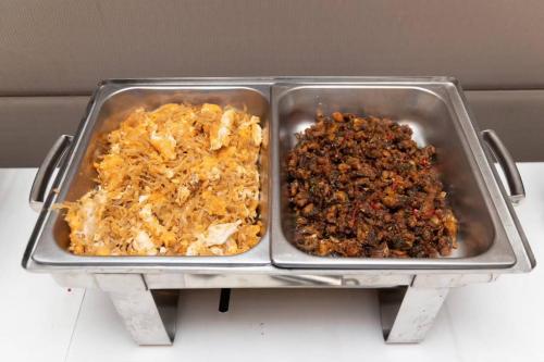 two metal trays of food on a table at Sukhothai Hotel and Residence Ratchada in Bangkok