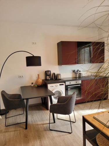 a kitchen with a table and chairs in a room at Waldstadt-Apartments in Iserlohn