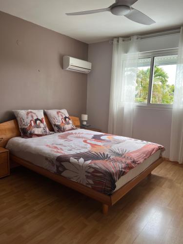 a bedroom with a bed and a window at Villa Étang salé les bains avec piscine privée in Étang-Salé les Bains