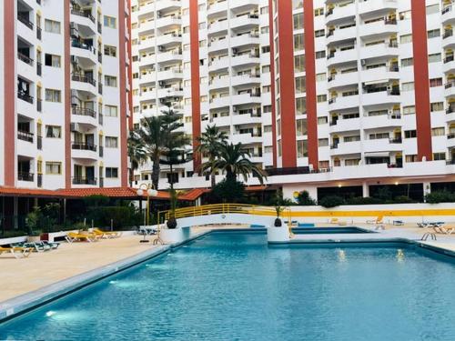 a swimming pool in front of some tall buildings at Stylish Apartment by Rocha Beach, Sleeps 5 in Portimão