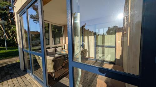 a glass door of a house with a patio at Taikos 7 in Nida
