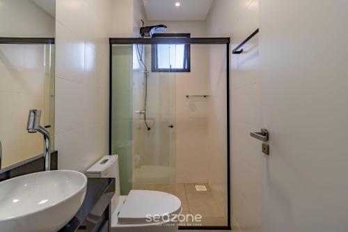 a bathroom with a glass shower and a sink at MHF II - Apts Variados em Prédio com Vista para o Mar em Itapema in Itapema