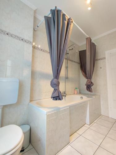 a bathroom with a bath tub and a toilet at City House Neuss in Neuss