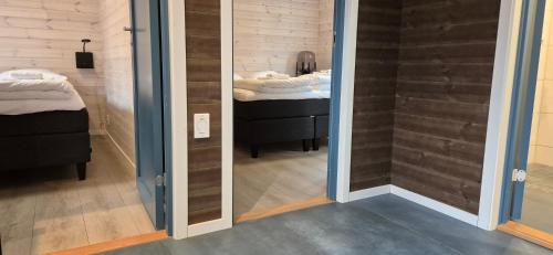 a mirror in a room with a bathroom with a sink at Andøy Vest Rorbuer Reine in Reine