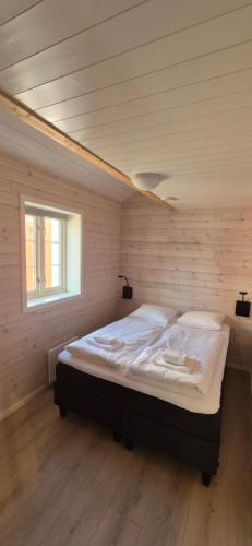 a bedroom with a bed in a room with a window at Andøy Vest Rorbuer Reine in Reine