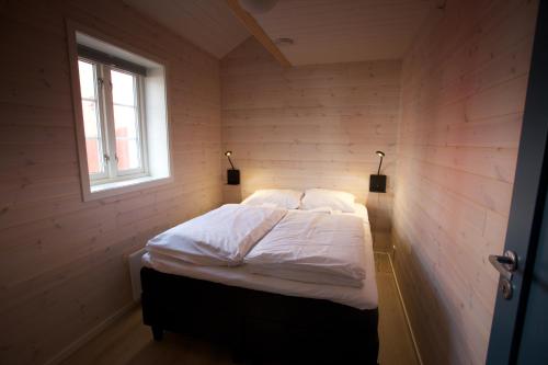 a bedroom with a bed in a room with a window at Andøy Vest Rorbuer Reine in Reine