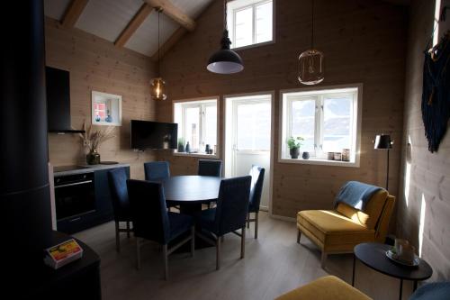 a living room with a dining room table and chairs at Andøy Vest Rorbuer Reine in Reine