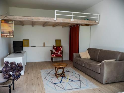 un salon avec un canapé et une table dans l'établissement La maison sous le noyer, à Montessut