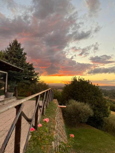 a sunset on a hill with a fence and flowers at Casa De Campo in Montegranaro