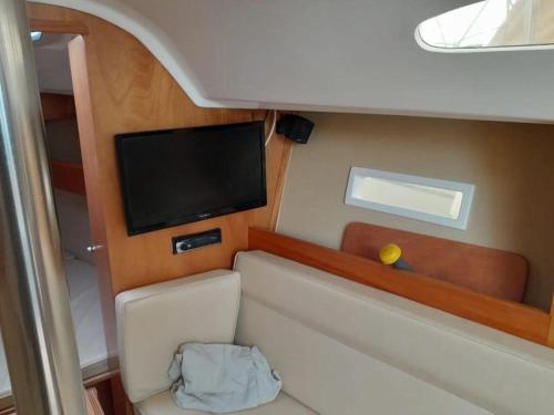 Una pequeña habitación con un televisor de pantalla plana en un barco. en Velero Viko S30, en Sitges