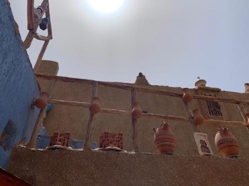 a building with vases on the side of it at Château Berbère Madame DELLAL in Taroudant