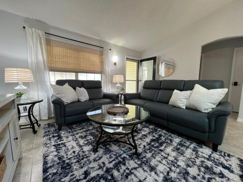 a living room with a couch and a glass table at Delia Place Florida Oasis With Private Lanai in The Villages