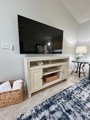 a living room with a large television on a wall at Delia Place Florida Oasis With Private Lanai in The Villages