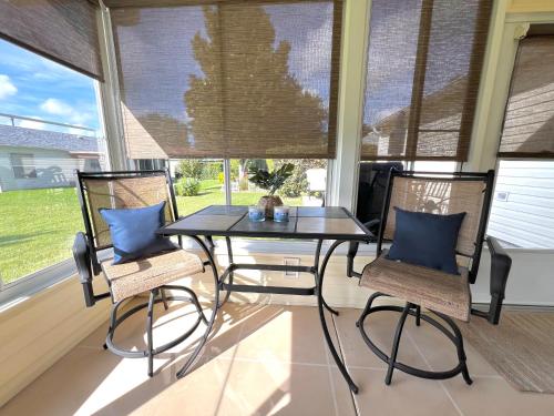 a screened porch with a table and two chairs at Delia Place Florida Oasis With Private Lanai in The Villages