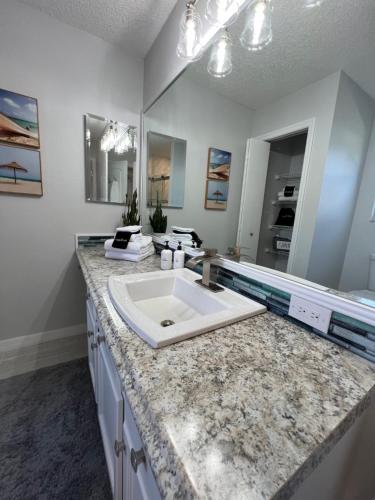a bathroom with a sink and a large mirror at Delia Place Florida Oasis With Private Lanai in The Villages