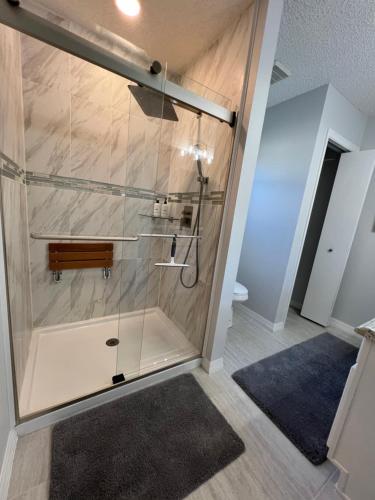 a shower with a glass door in a bathroom at Delia Place Florida Oasis With Private Lanai in The Villages