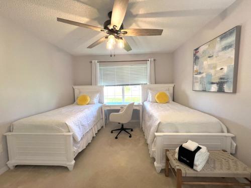 a bedroom with two beds and a ceiling fan at Delia Place Florida Oasis With Private Lanai in The Villages