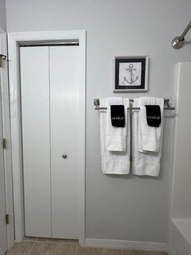 a bathroom with white towels hanging on a wall at Delia Place Florida Oasis With Private Lanai in The Villages