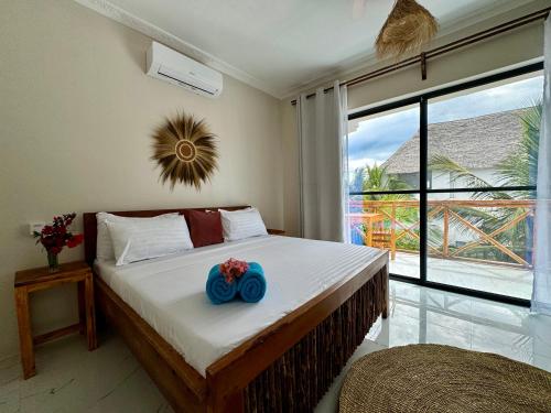 a bedroom with a bed with a blue flower on it at Rafiki Hotel Nungwi Beach in Nungwi
