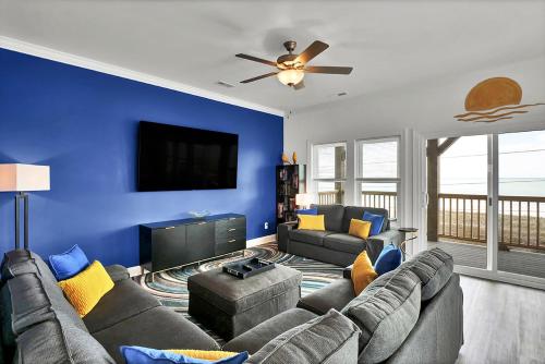 een woonkamer met een bank en een tv bij Oceanside Oasis by Sea Scape Properties in North Topsail Beach