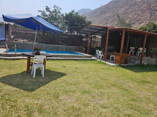 une cour arrière avec une table, des chaises et une piscine dans l'établissement Casa de Campo La Chocita de Gladis, à Santa Rosa de Quives