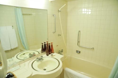 a bathroom with a sink and a shower and a tub at Hotel New Otani Nagaoka in Nagaoka