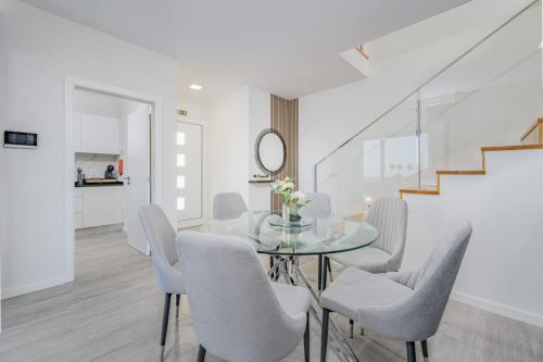 a dining room with a glass table and chairs at JPL Blue Horizon Residential - Casa Horizon A in Câmara de Lobos