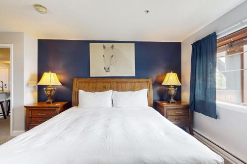 a bedroom with a large white bed with two lamps at First Tracks 4202 in Steamboat Springs