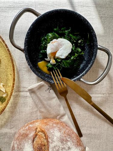 a bowl of food on a table with a fork and bread at Wellness apartmány Český ráj & Biokolna in Lomnice nad Popelkou