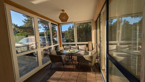 a screened in porch with a table and chairs at Taikos 7 in Nida