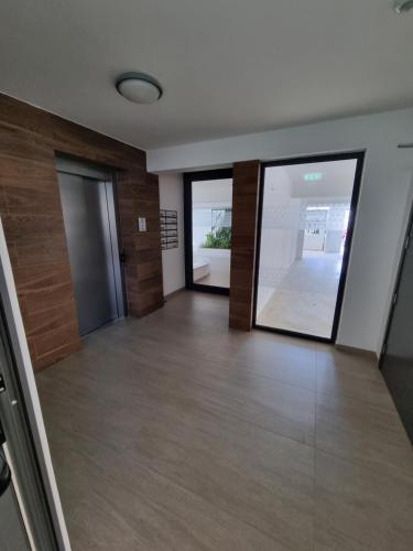 an empty room with glass doors and wooden floors at Cosmos Residence in Paralimni