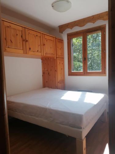 une chambre avec un lit et deux fenêtres dans l'établissement Station ORELLE-VAL THORENS, app 4-6 pers, piscine et spa, à Orelle