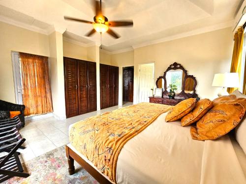 a bedroom with a large bed with a ceiling fan at Mais Oui Villa in Discovery Bay