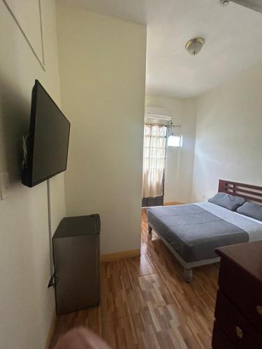 a bedroom with a bed and a flat screen tv at Hotel City Central Guayaquil in Guayaquil